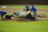Members of the grounds crew cover the mound during a rain delay in the fifth inning of Game One of the American League Championship Series betweent the Detroit Tigers and the Texas Rangers at Rangers Ballpark in Arlington on October 8, 2025 in Arlington, Texas.  (Photo by Kevork Djansezian/Getty Images)